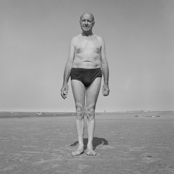 photographie noir et blanc viel homme debout en maillot de bain sur la plage